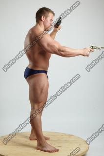 ADAM WARD STANDING WITH TWO GUNS